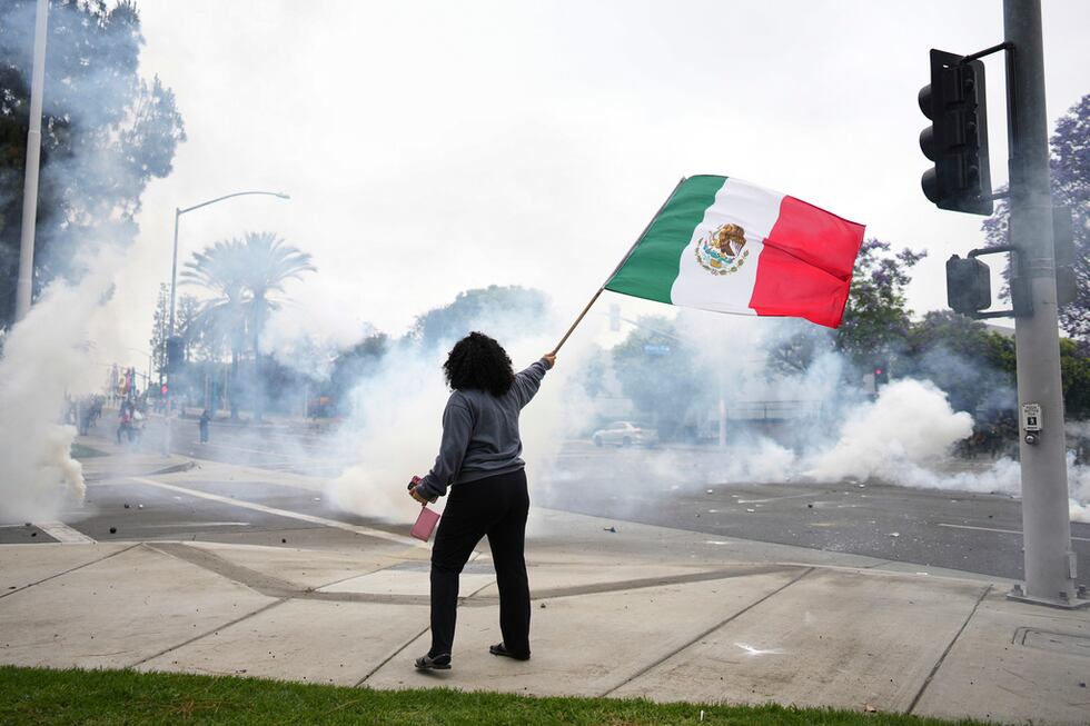 Una mujer ondea una bandera mexicana durante una protesta en la sección Paramount de Los...