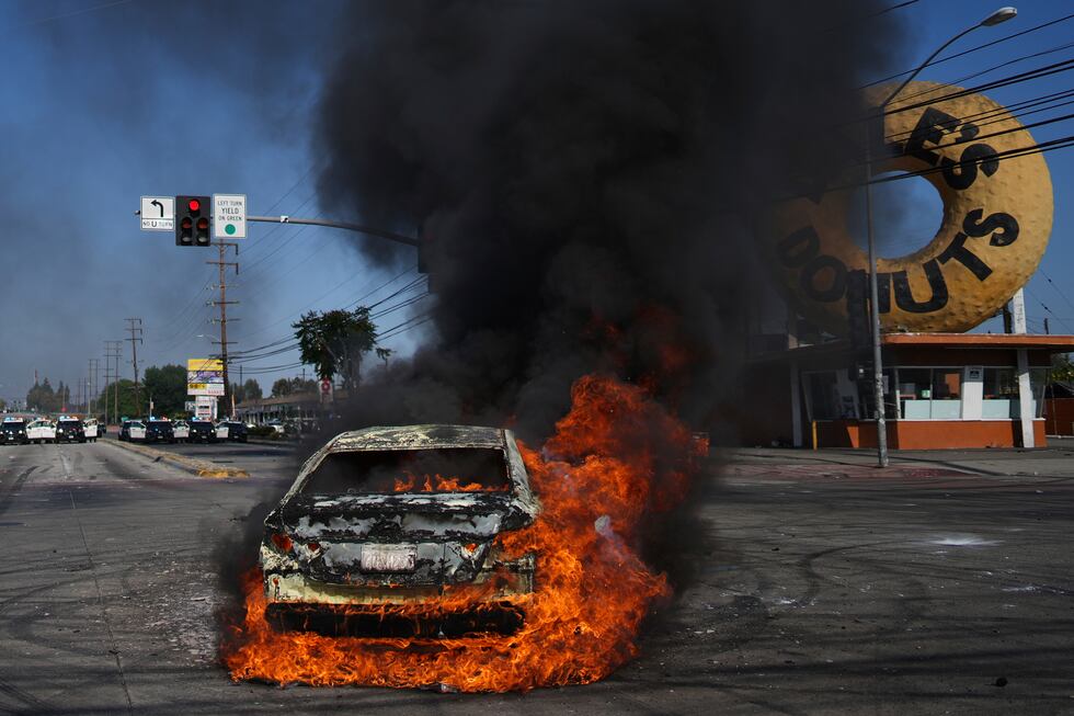 Un auto arde durante una protesta en Compton, California, el sábado 7 de junio de 2025,...