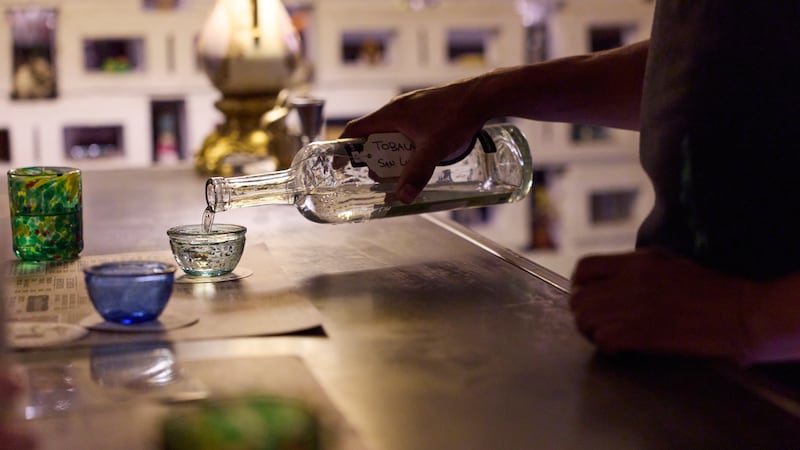 Un camarero sirve un vaso de mezcal en la destilería In Situ en la ciudad de Oaxaca, México,...