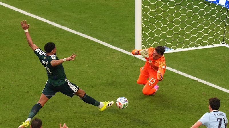 Abdulelah Alamri, de Arabia Saudí, anota frente al arquero uruguayo Fernando Muslera en un...